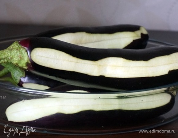 Баклажаны хорошо промыть, плодоножки не срезать, а готовить с ними, так баклажаны будут лучше держать форму. Далее баклажаны нужно очистить «зеброй», то есть срезать кожицу продолговатыми полосками, чередуя полоска с кожицей и полоска без. Это делается и для эстетики, и для улучшения их вкуса. По середине вдоль сделать надрез глубиной примерно 2 см. После чего залить баклажаны подсоленной водой и оставить на 30 минут.