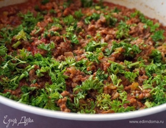 Пока баклажаны остывают, займемся начинкой. Лук и чеснок мелко нарезать и обжарить на сливочном масле до легкой золотистости. Добавить мелко нарезанный перец. Готовить 2–3 минуты. Добавить фарш, перемешать и потушить 3–4 минуты. Затем добавить 1 столовую ложку томатной пасты, перемешать и потушить еще минутку. Помидоры очистить и измельчить в кашицу или натереть на терке и добавить к фаршу. Посолить и поперчить по вкусу. Добавить кориандр, кумин, острый красный перец по вкусу. В конце добавить мелко нарезанную петрушку, перемешать и снять с огня. Начинка готова.
