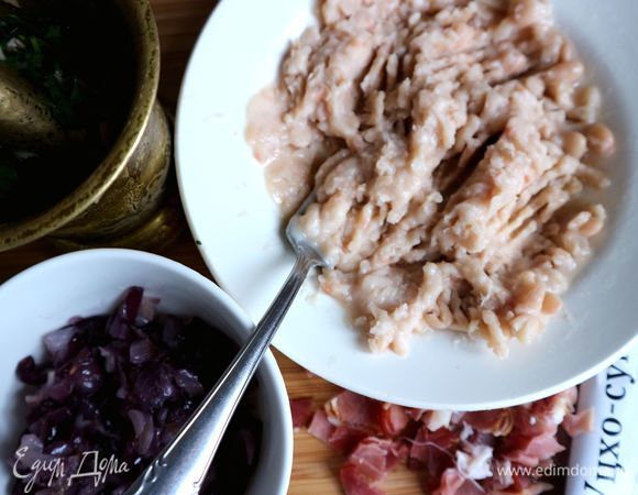 В ступку положить кинзу, 5 г растительного масла, красный винный уксус, немного фасоли, чеснок, потолочь. Фасоль в миске размять вилкой.