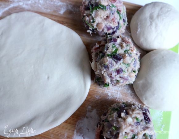 Сплющить немного шар из теста, затем раскатать сначала 1 шар из теста скалкой. Рекомендуется при раскатывании теста делать чуть-чуть тоньше края, чтобы при формовке не было в центре теста утолщения. Начинка, если вы ее скатаете в шар, должна быть такой же по размеру, как шар из теста.