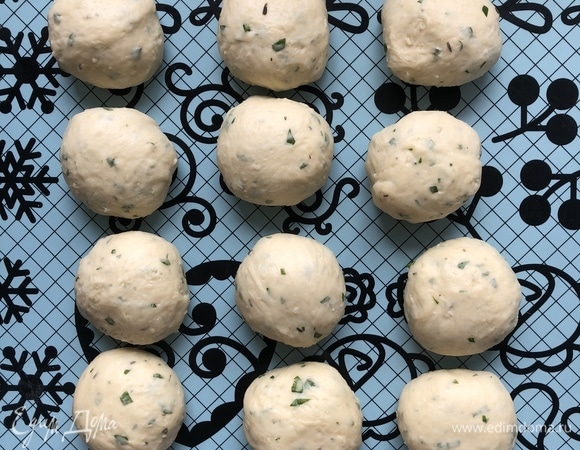 Разделить тесто на 12 кусков, скатать в шары. Выложить заготовки булочек в огнеупорную форму (дно слегка смазать сливочным маслом).