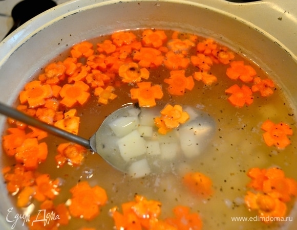 Воду вскипятить, добавить нарезанную кубиком картошку, морковь, нарезанную в форме цветочков, специи, соль по вашему вкусу.