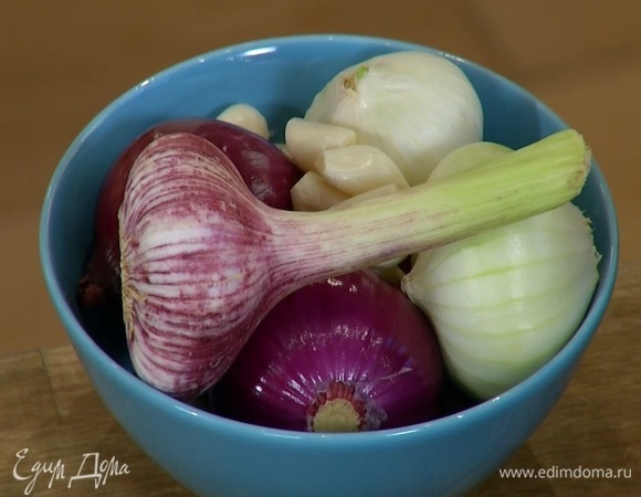 Головку чеснока почистить, выложить в маленькую сковороду и влить оливковое масло.