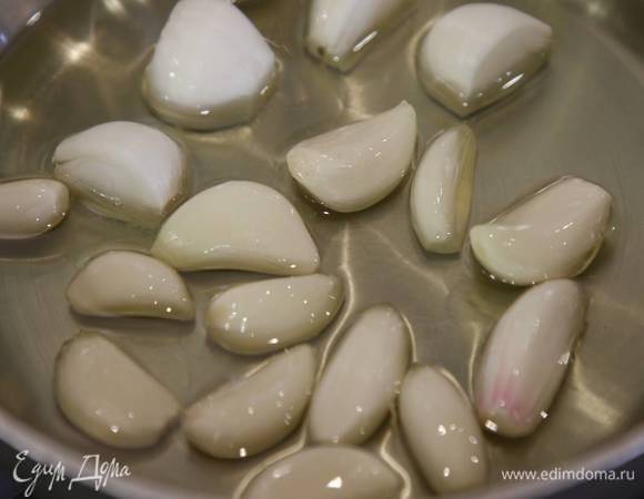 Побег чеснока разрезать на 4 части, добавить в сковороду и томить на маленьком огне до прозрачного, янтарного цвета.