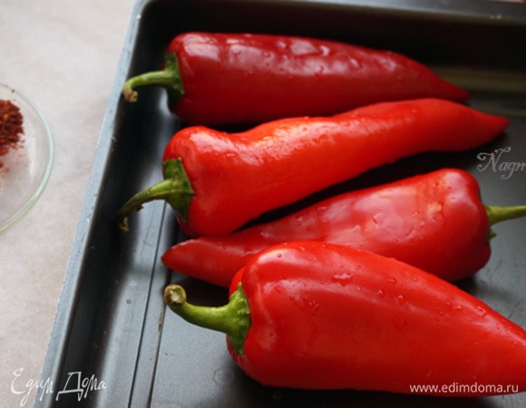 Нагрейте духовку до 200°C. Выложите на противень перцы и запекайте их 15–20 минут.