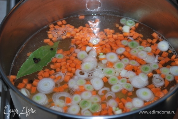 В процеженный рыбный бульон положите морковь, лук и картофель. Варите бульон до полуготовности овощей.