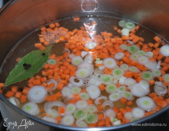 В процеженный рыбный бульон положите морковь, лук и картофель. Варите бульон до полуготовности овощей.