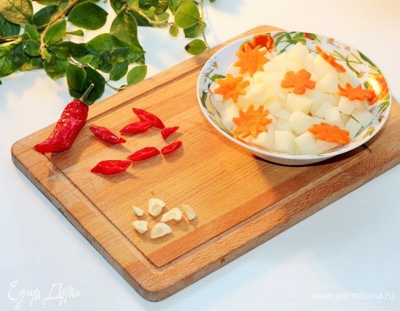 Острый перец и чеснок нарезать кружочками. Картофель — кубиками.