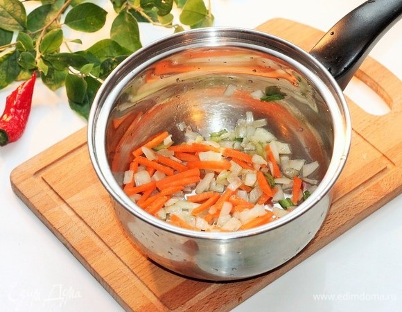 На чесночном масле обжарить лук до прозрачности, затем добавить морковь и пассеровать овощи.