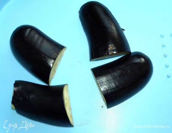 Очень крупные баклажаны лучше не брать. Баклажаны моем, срезаем плодоножки, разрезаем пополам и каждую часть делим на две половины. Можно баклажаны очистить.