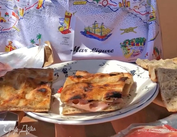 Накрыть бутерброд верхней частью фокаччи и разрезать пополам.