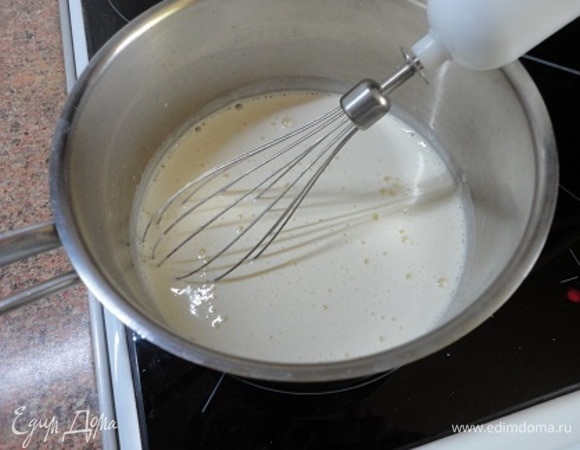 Пока коржи остывают, приготовим крем. Смешаем сахар с крахмалом и ванильным сахаром в маленькой кастрюльке. Добавьте в кастрюлю яйца и хорошо взбейте. Влейте в эту смесь молоко. Поставьте кастрюлю на плиту со средним нагревом и варите, постоянно помешивая, пока крем не загустеет. Не доводите до кипения. Если все-таки образовались комочки, протрите жидкость через сито. Остудите.