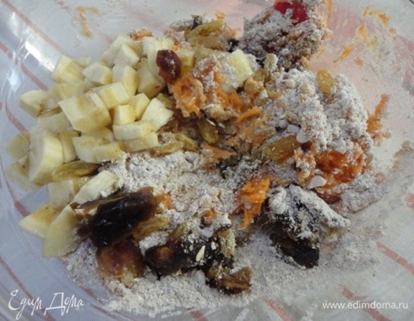 В глубокой чаше взбить яйца с оливковым маслом. Всыпать в яично-масляную смесь сухие ингредиенты, морковь, банан и сухофрукты. Перемешать.