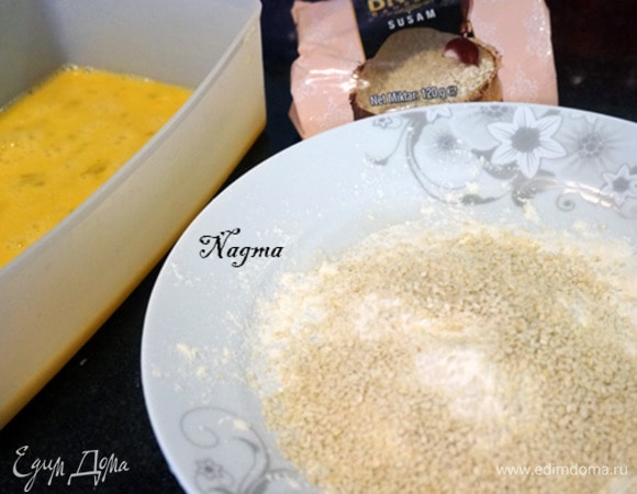 В глубокую миску разбить три яйца. Взбить их венчиком или вилкой. На тарелку насыпать муку, добавить кунжут и перемешать.