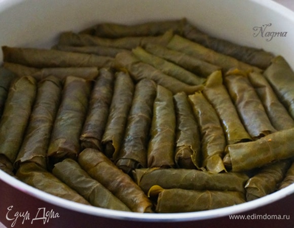 Теперь аккуратно выкладываем нашу сарму в кастрюлю, желательно с толстым дном. Дно кастрюли лучше застелить оставшимися виноградными листьями (используйте порванные листья, которые непригодны для сармы), чтобы сарма не подгорела и не прилипла.