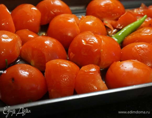 Помыть помидоры и халапеньо или 1 зеленый чили, обсушить. Помидоры разрезать пополам. Противень смазать оливковым маслом, выложить помидоры и перец.