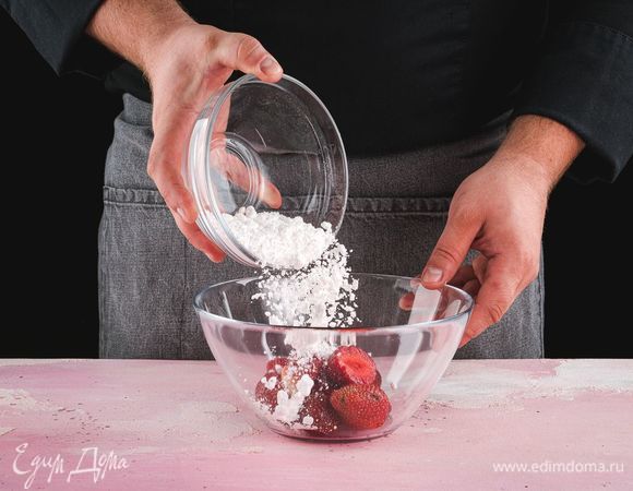 Клубнику засыпьте оставшейся сахарной пудрой, слегка перемешайте и дайте постоять.