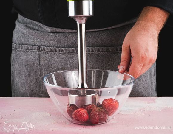 Половину клубники с сахарной пудрой поместите в чашу блендера и измельчите до однородной консистенции.