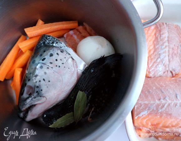 Подготовить голову семги: вынуть жабры, удалить глаза. В кастрюлю положить голову семги (предварительно и голову, и хвостовую часть промыть проточной холодной водой), хвостовую часть, позвоночную часть, перец горошком (черный и душистый), очищенный от шелухи лук (1 шт.), очищенную морковь, нарезанную на несколько частей, соль. Налить холодную воду, поставить на средне-сильный огонь, дать закипеть, укрепиться пене, снять пену, убавить огонь. Варить примерно 1 час.
