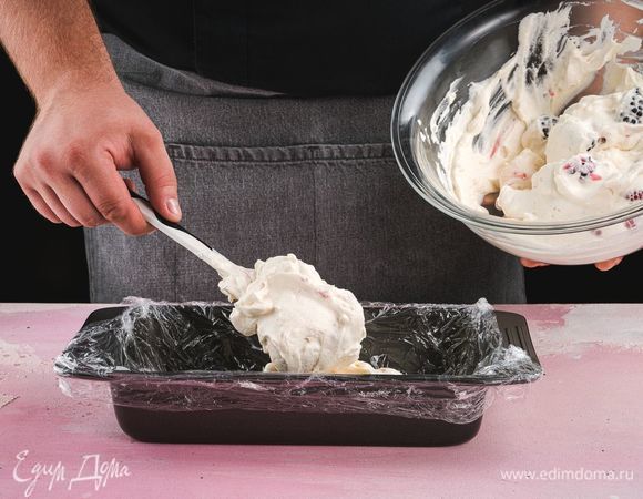 Форму для торта или глубокую чашу застелите пищевой пленкой, выложите часть крема с ягодами и разровняйте.