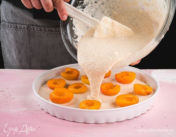 Выложите половинки абрикосов, а сверху — вторую часть теста.