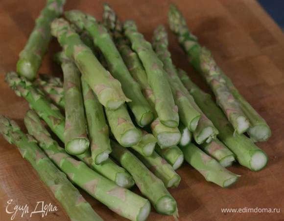 Спаржу, отломив грубые черенки, выложить в один слой на дно жаропрочной керамической формы.