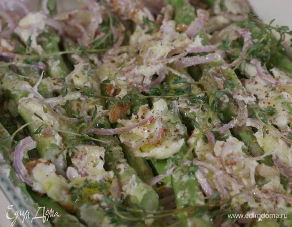 На спаржу выложить чеснок, лук, орехи, кусочки размягченного сливочного масла, посолить, поперчить, накрыть веточками тимьяна и слегка полить оливковым маслом.