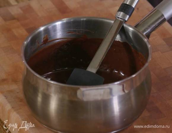 Оставшийся шоколад поломать кусочками, выложить в кастрюлю, влить 20 мл воды и растопить.