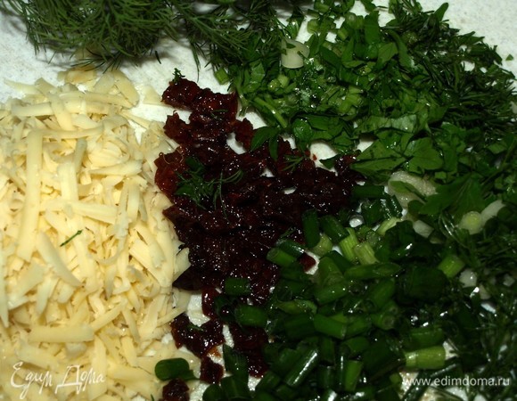 Духовку разогреть до 180°C. Кабачки хорошо вымыть, срезать плодоножки (вес кабачков указан до обработки). Натереть на крупной терке. Отжать лишний сок (сок использовать для смузи). Укроп, петрушку, зеленый лук мелко порубить, сыр натереть на терке, вяленые томаты мелко нарезать.