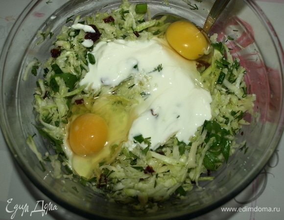 Соединить в миске отжатые кабачки, сыр, зелень, вяленые томаты. Добавить йогурт, куриные яйца, растительное масло. Все перемешать.