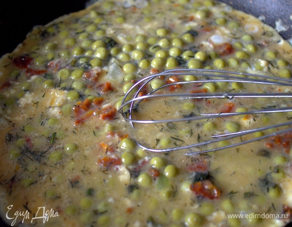 Когда края затянутся, начинаем шевелить омлет венчиком.