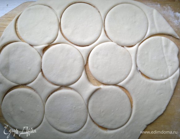 Тесто разделить на 2–3 части. Каждую часть раскатать в пласт толщиной 2–3 мм на столе или доске, подпыленной мукой. С помощью стакана вырезать кружки.