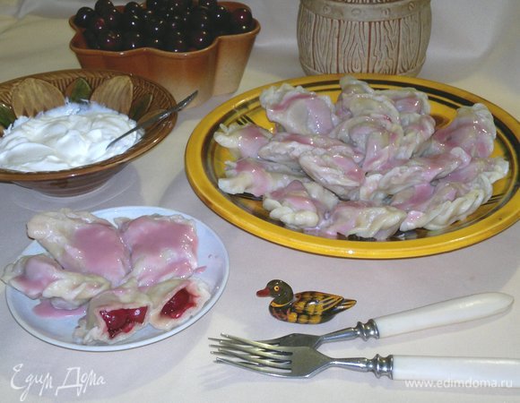 Готовые вареники с вишнями выложить на блюдо, полить соусом. Сметану с сахаром подать отдельно. Угощайтесь! Приятного аппетита!