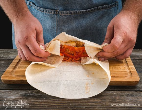 Затем добавьте морковь по-корейски. Сверните лаваш в ролл.