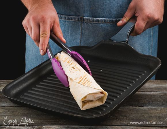 Разогрейте сковороду-гриль и обжарьте шаурму с двух сторон, чтобы лаваш стал хрустящим. Разрежьте пополам и украсьте свежей зеленью.