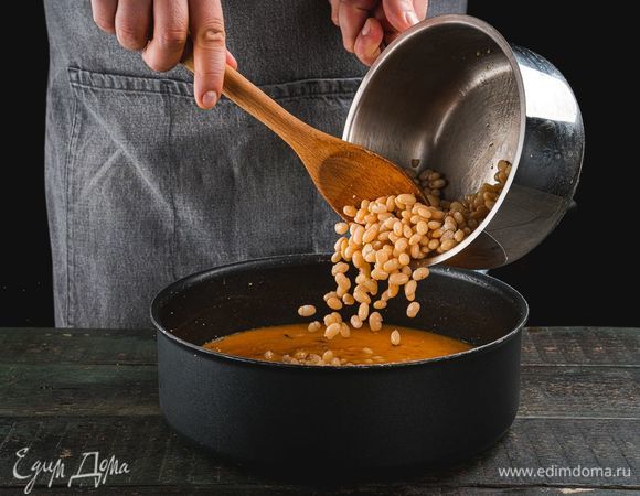 Добавьте в сковороду отварную фасоль, накройте крышкой и дайте покипеть 7 минут.