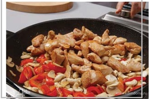 К готовым овощам добавьте обжаренную курицу, все смешайте, добавьте орехи кешью, накройте крышкой и прогрейте все 2 минуты в сковороде.