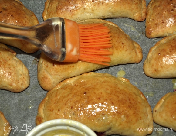 Достаем готовые пирожки и горячими смазываем сливочным маслом.