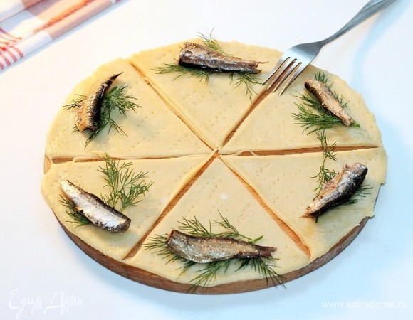 На каждую часть теста кладем по одной рыбке и небольшой веточке укропа. Закручиваем начинку.