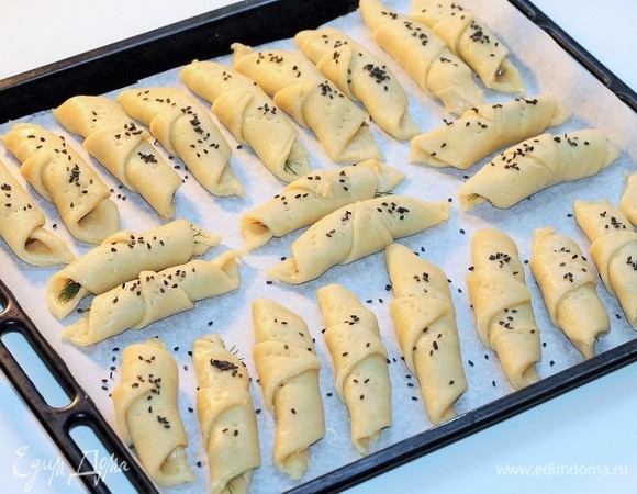 На противень, застеленный бумагой для выпечки (не смазываем маслом), выкладываем охлажденные рогалики. Рогалики обязательно проколоть вилкой, чтобы не потрескалось тесто при выпечке.
