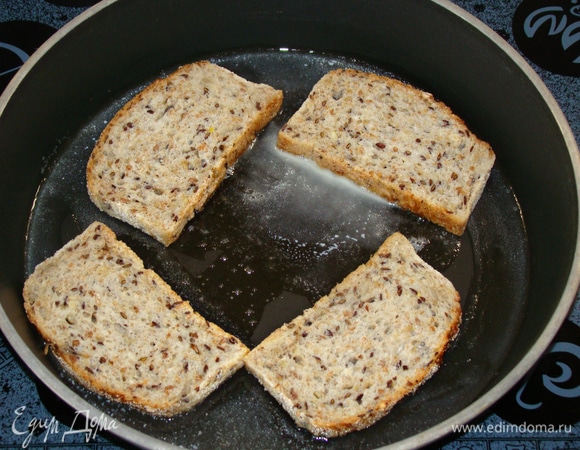 Пока яйца запекаются, поджарить ломтики цельнозернового хлеба на сливочном масле до румяной корочки.