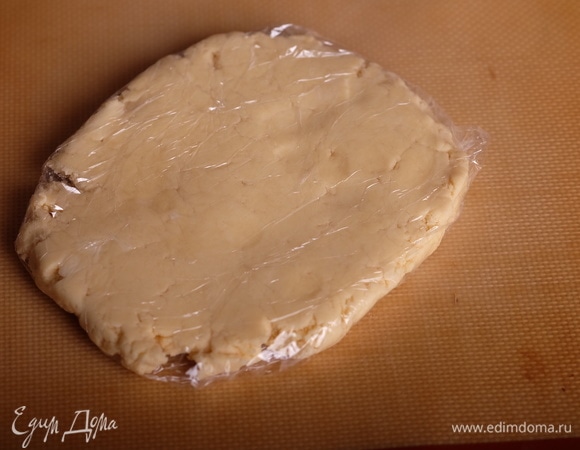 Приготовить песочное тесто. Для этого взбить сливочное масло комнатной температуры с сахарной пудрой до пышности, добавить желток, соль, миндальную эссенцию и снова взбить. Просеять смешанную с солью и разрыхлителем муку, быстро замесить тесто. Долго не мешать — как только тесто собралось в ком, собрать, сделать из теста брусок, завернуть в пищевую пленку и поместить в холодильник минимум на 3 часа.