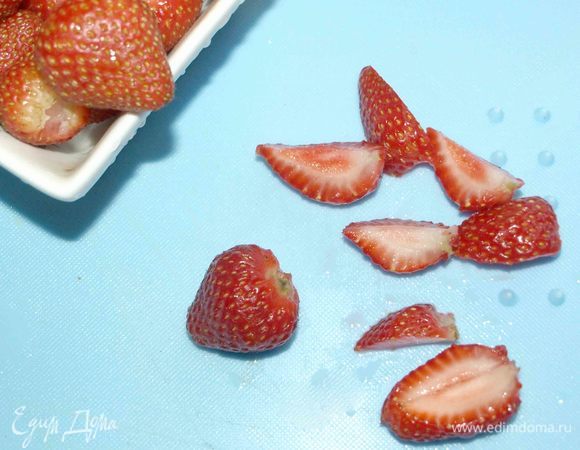 Клубнику промыть, удалить плодоножки и разрезать на несколько частей.