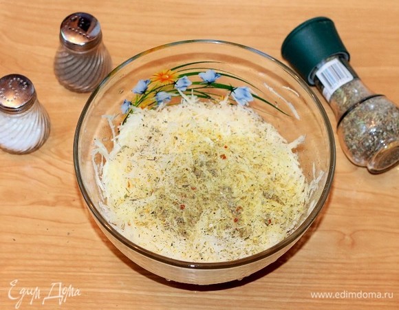 Очищенный картофель натираем на средней терке и выжимаем сок. Добавляем к картофелю приправу, прессованный чеснок, соль и перец. Перемешиваем.