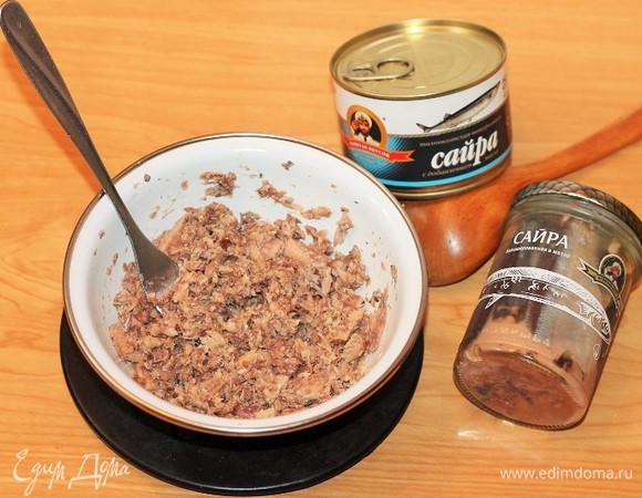 Выкладываем сайру без масла из банки и измельчаем вилкой.