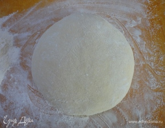 Подошедшее тесто обминаем и выкладываем на подпыленный мукой стол или доску.