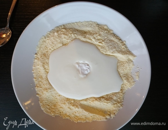 Сделать небольшое углубление типа кратера. Добавить кефир, а в него — соду. Соду можно не гасить, так как она погасится кефиром.