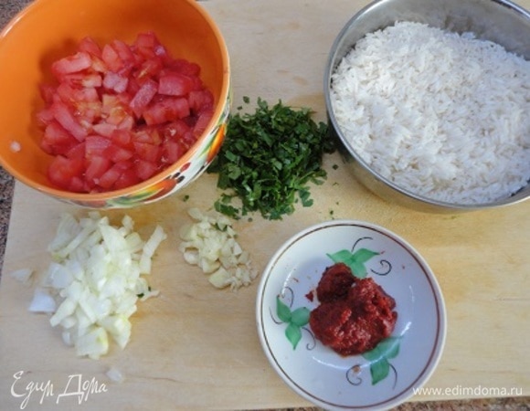 Лук и чеснок почистить и измельчить. Помидоры очистить от кожицы и нарезать кубиками. Кинзу мелко нарубить.
