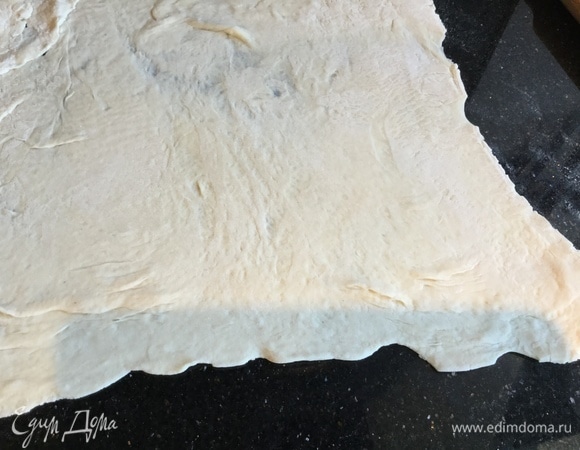 Слоеное тесто раскатайте. Противень застелите бумагой для выпечки и выложите тесто, сделав бортики.