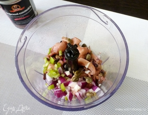 В чашу блендера сложить морской коктейль, каперсы, чили, лук и чеснок, нарезанные на кусочки. Измельчить.